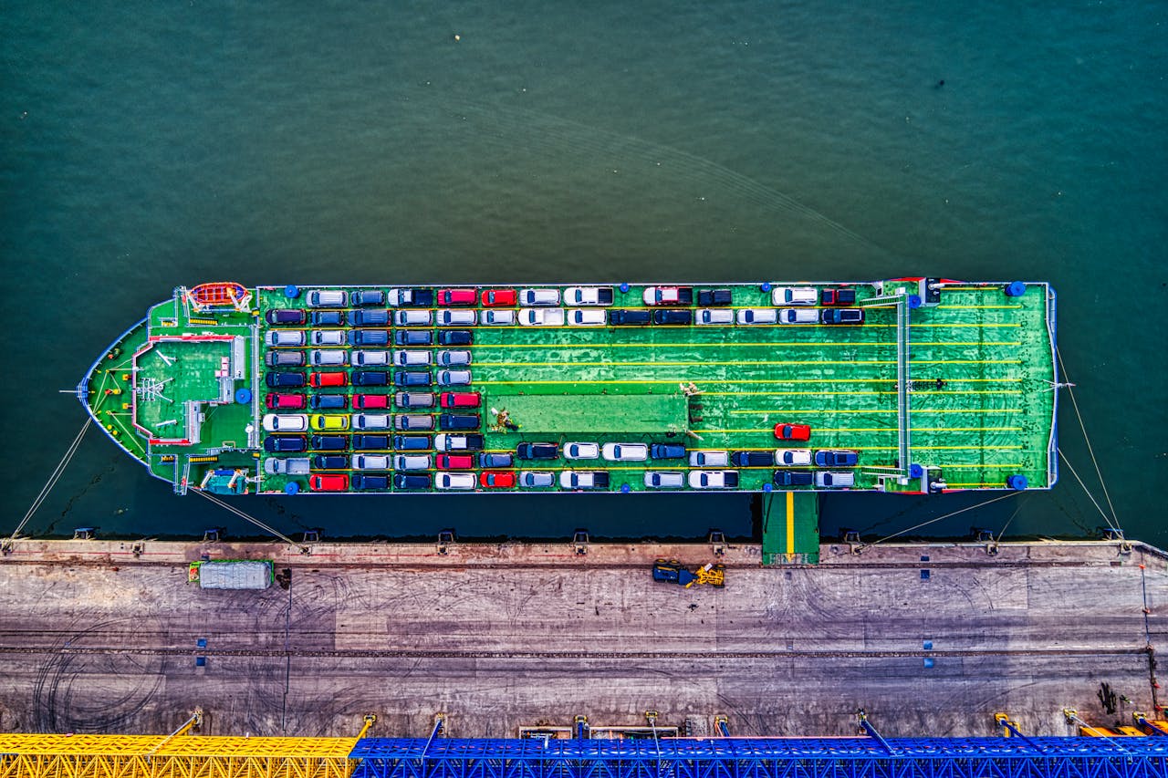 our-services-2 Aerial view of a car transport ship docked at Bekasi port, Indonesia.